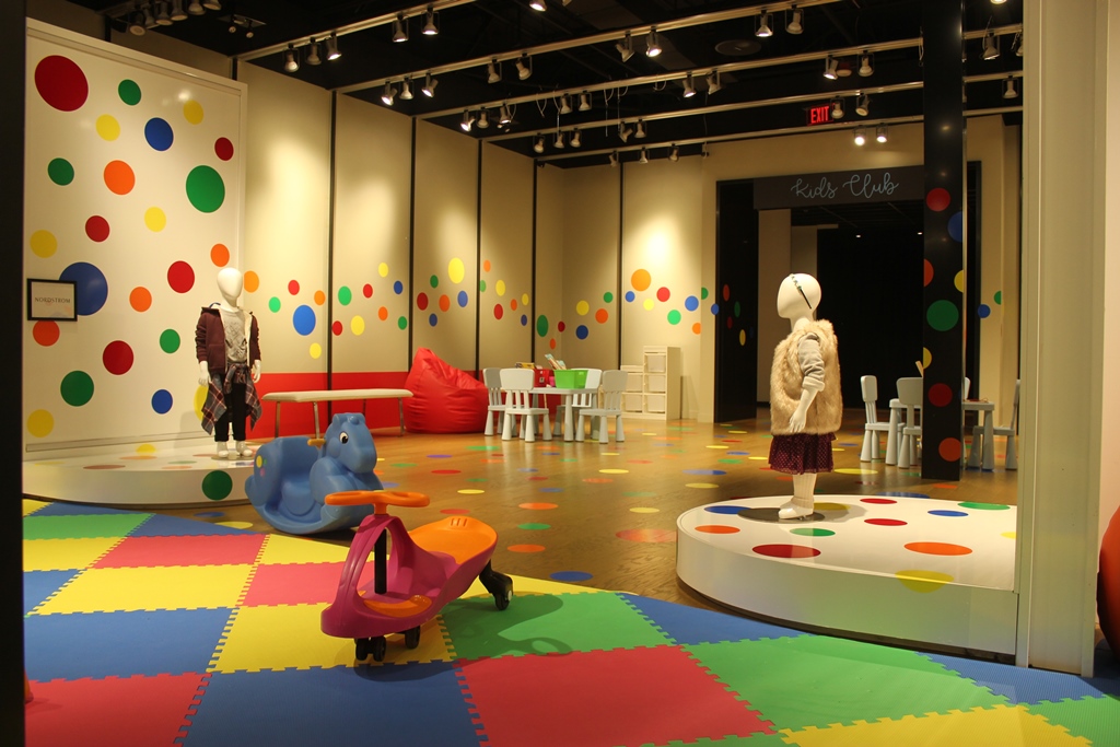 a room with a colorful floor and a group of mannequins